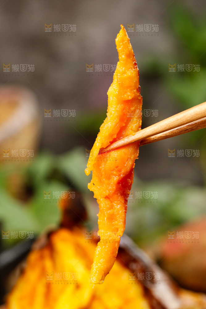 筷子上夹着红蜜薯