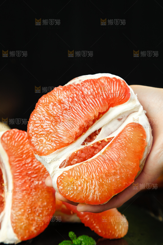 手上拿着红心柚果肉