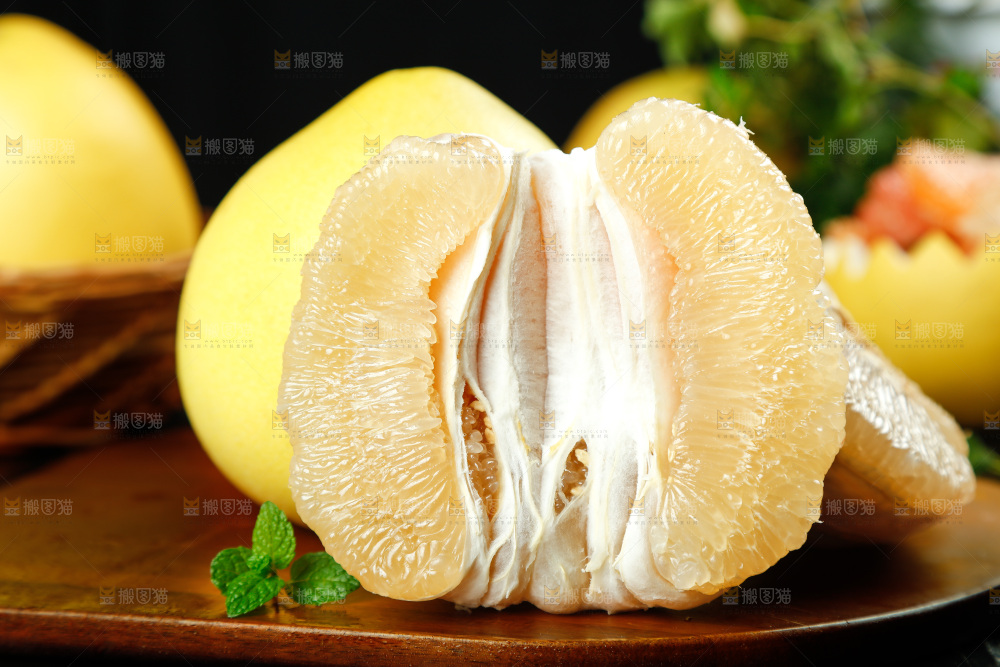 木板上放着蜜柚和白心蜜柚果肉