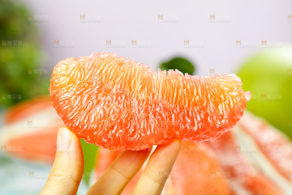 手上拿着泰国红心蜜柚果肉