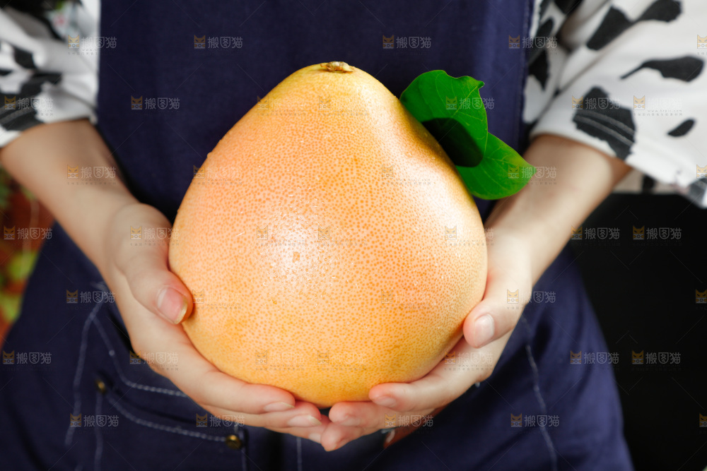 手里拿着红心蜜柚