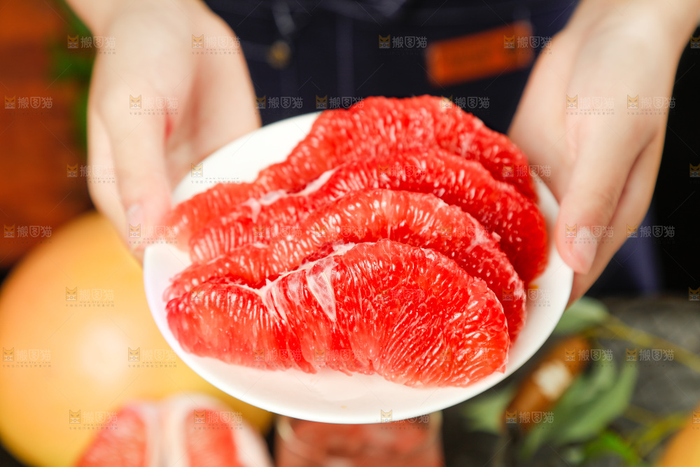 手里捧着剥皮的红心柚子