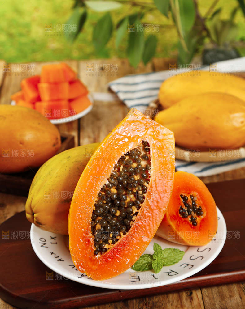 木板上放着切开的冰糖心木瓜