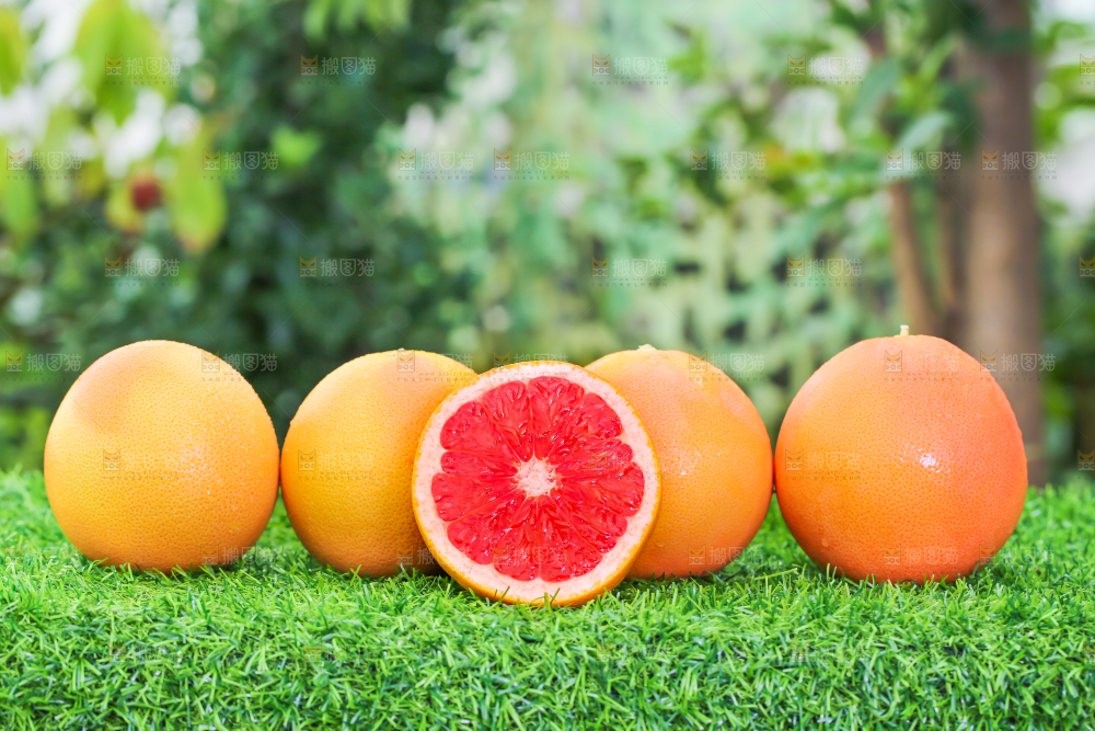 草地上放着切开的红心西柚
