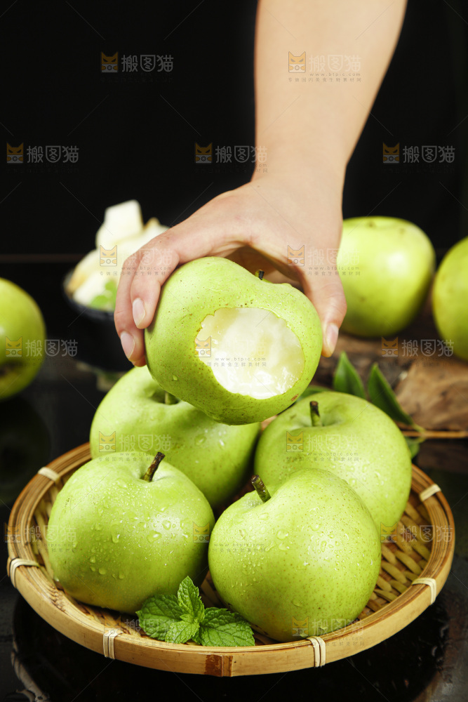 黑底上手拿一个苹果梨