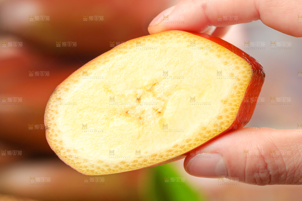 浅底上手拿着一块红皮香蕉