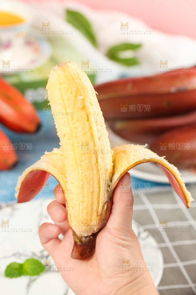 浅底上手拿剥皮的红皮香蕉