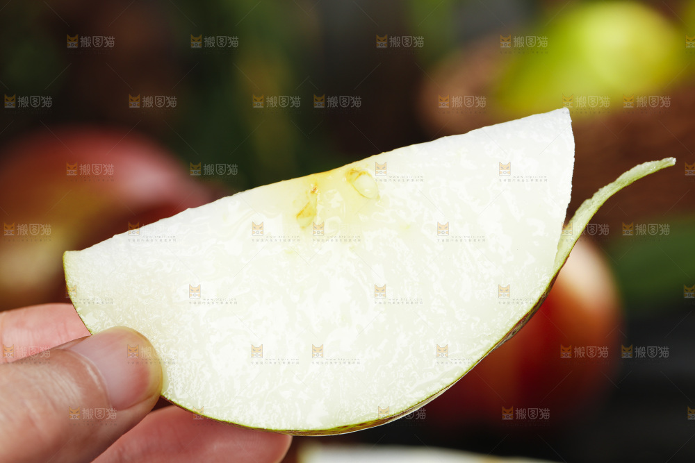 手拿切开的彩虹梨