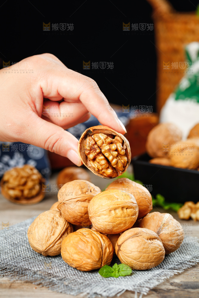 手拿剥开的纸皮核桃