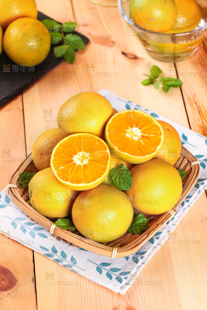 木板上放着一篮切开的夏橙