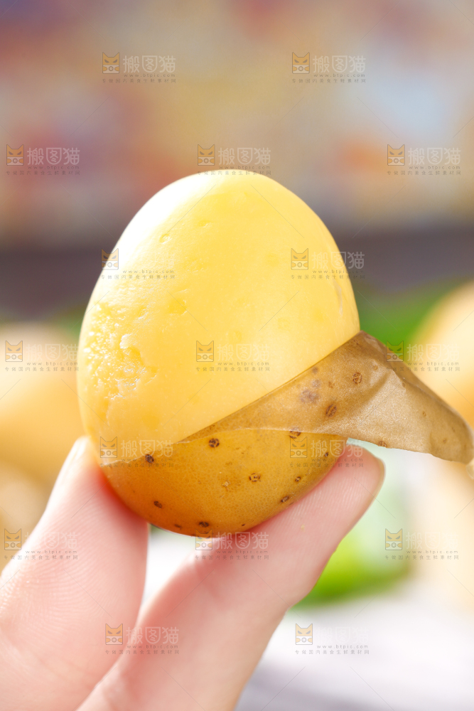 手拿剥皮的黄心熟土豆