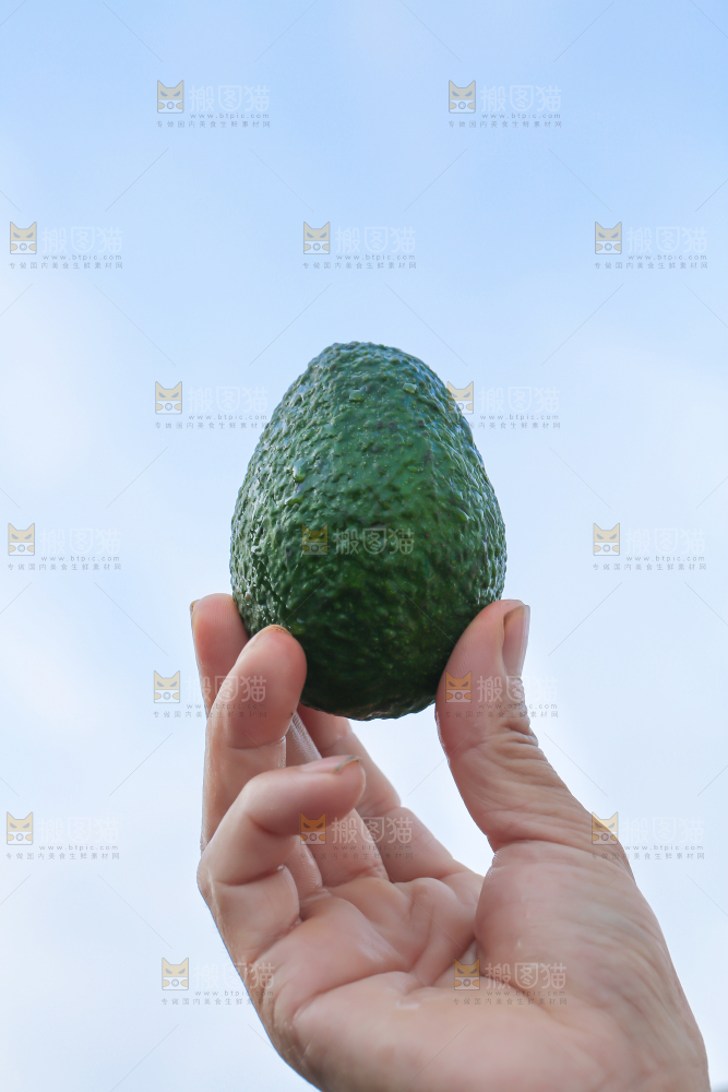 手里拿着牛油果