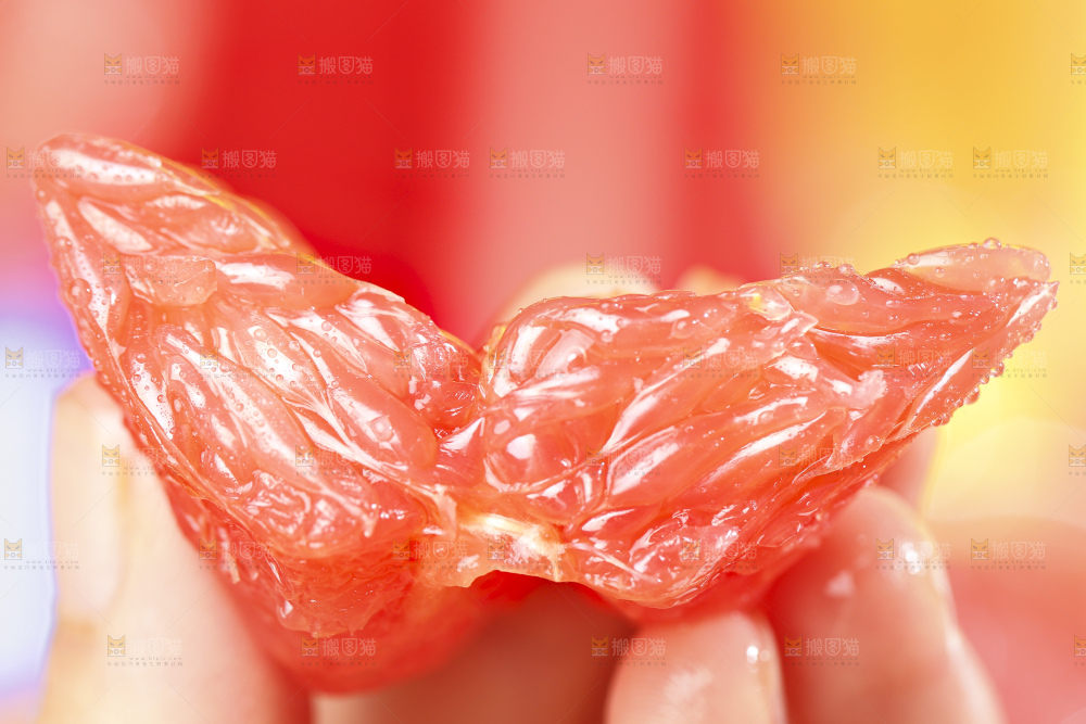 手拿着剥皮的红心葡萄柚果肉