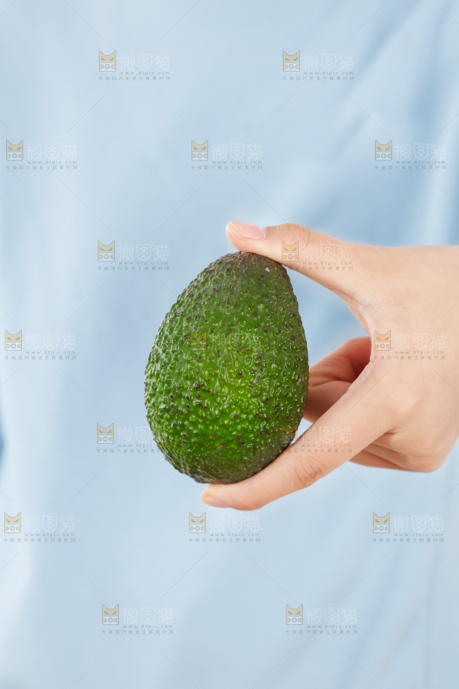 手里拿着牛油果