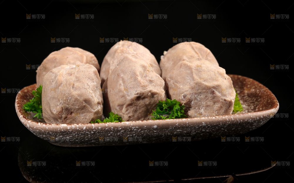 一盘潮汕牛肉丸放在黑底上