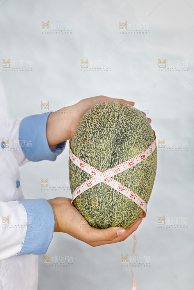 手里正在测量哈蜜瓜