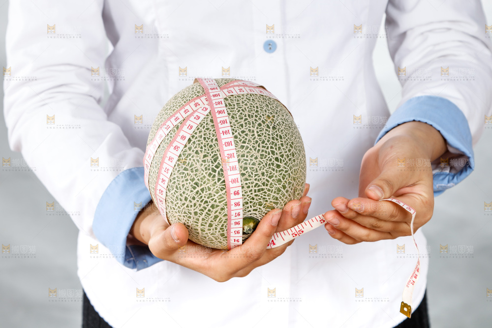 手里正在测量哈蜜瓜