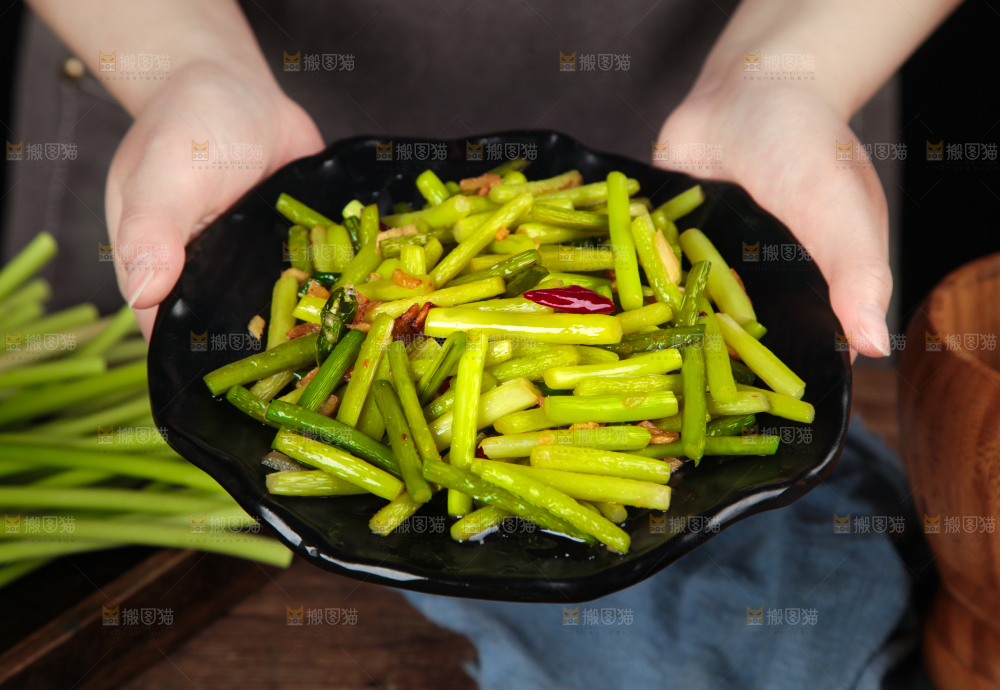 手拿一盘清炒蒜苔