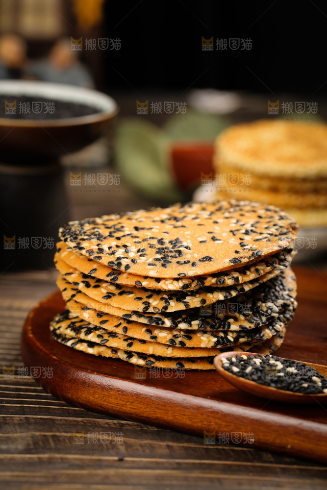 木板上放着手工芝麻饼