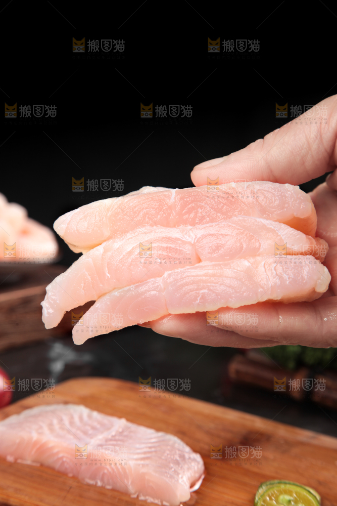 手拿新鲜的巴沙鱼块
