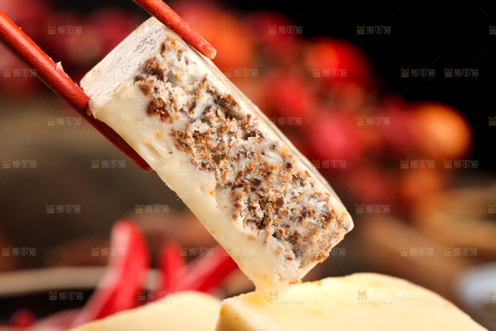 筷子夹着一块清汤火锅底料