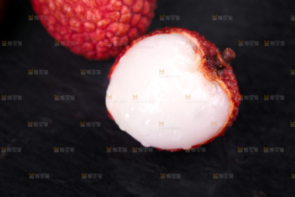 剥皮的新鲜荔枝放在黑底上