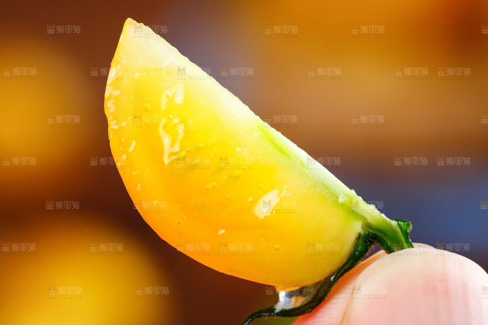 手拿切开的黄金圣女果