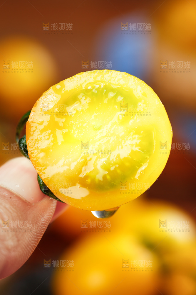 手拿切开的黄金圣女果