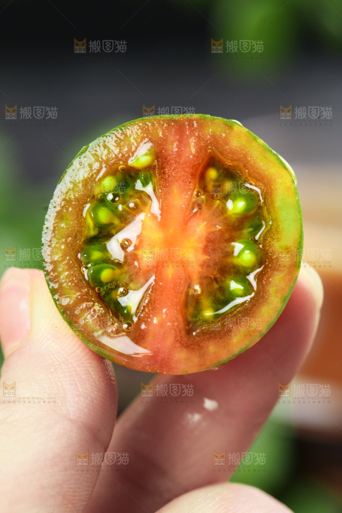 手拿切开的迷彩圣女果