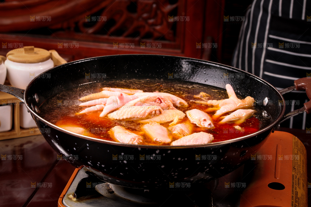 锅里装着正在卤鸡爪和鸡中翅