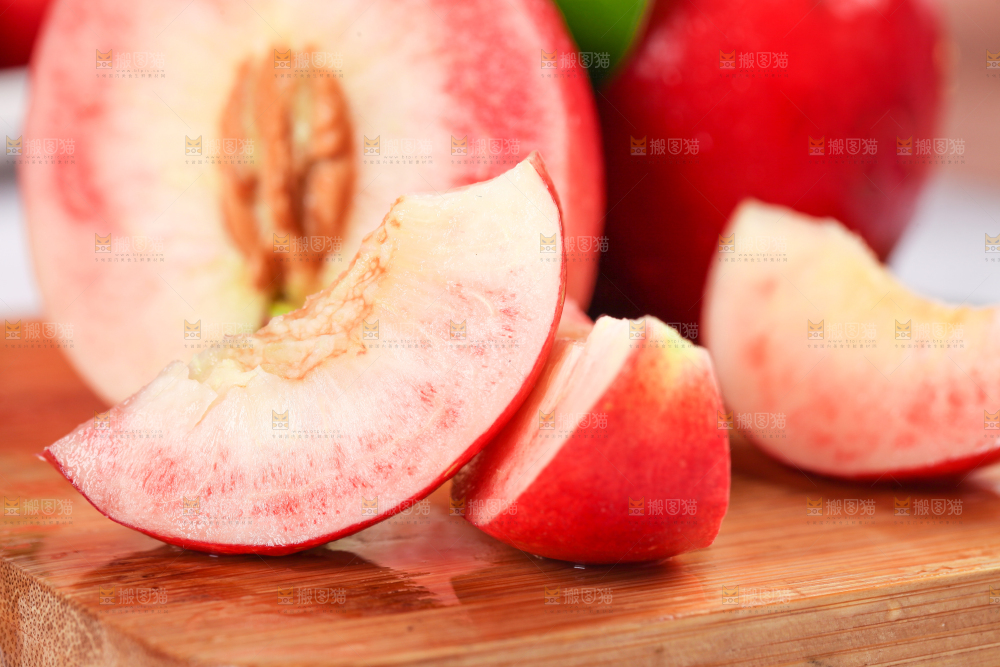 木板上摆放着红心桃子