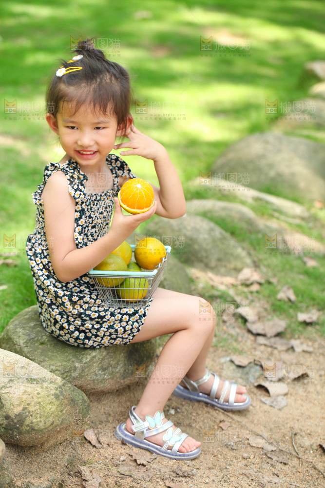 小女孩小手里拿着夏橙