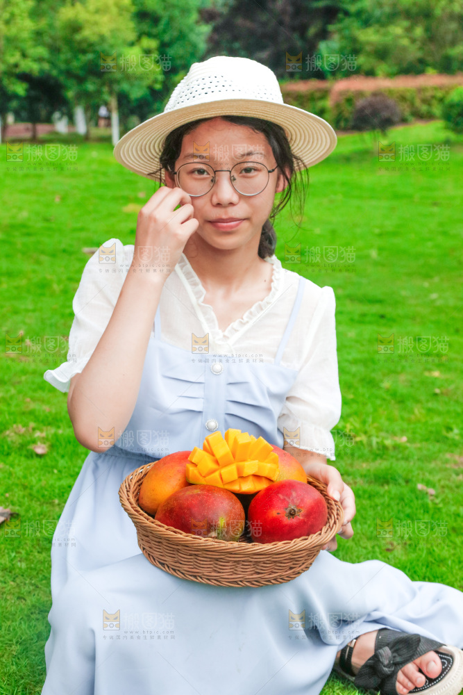 女孩手里端着一篮芒果