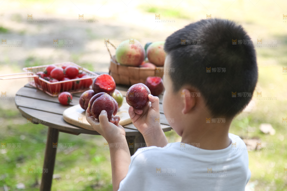 小男孩手里拿着水果