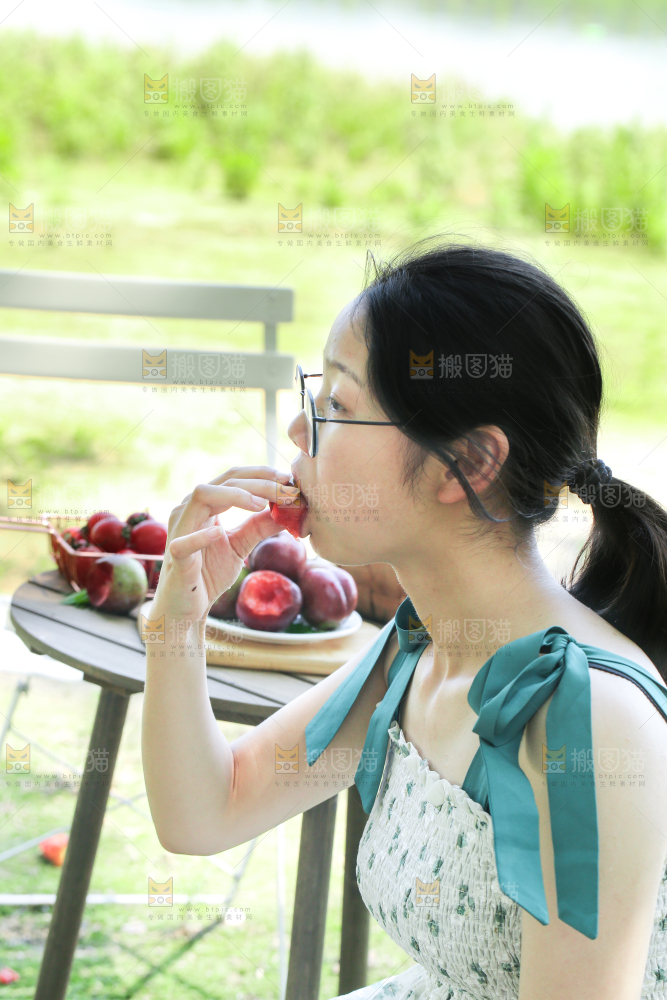 女孩正在吃红肉李子