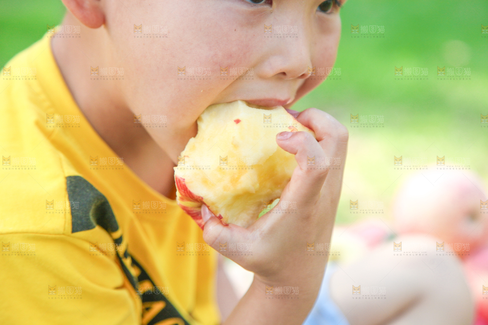 小男孩正在吃苹果
