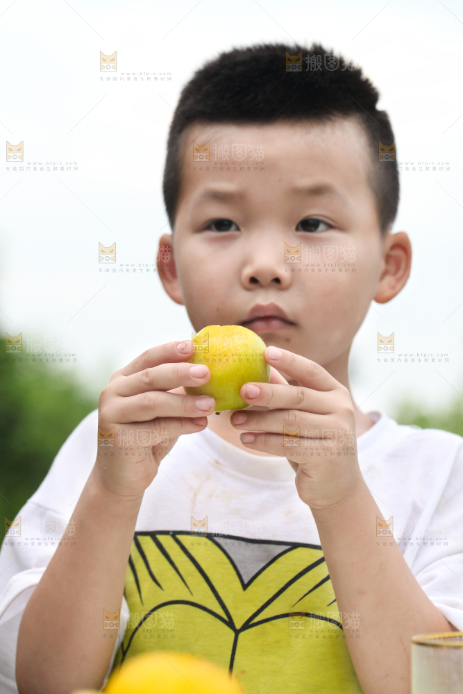 小男孩正在吃李子