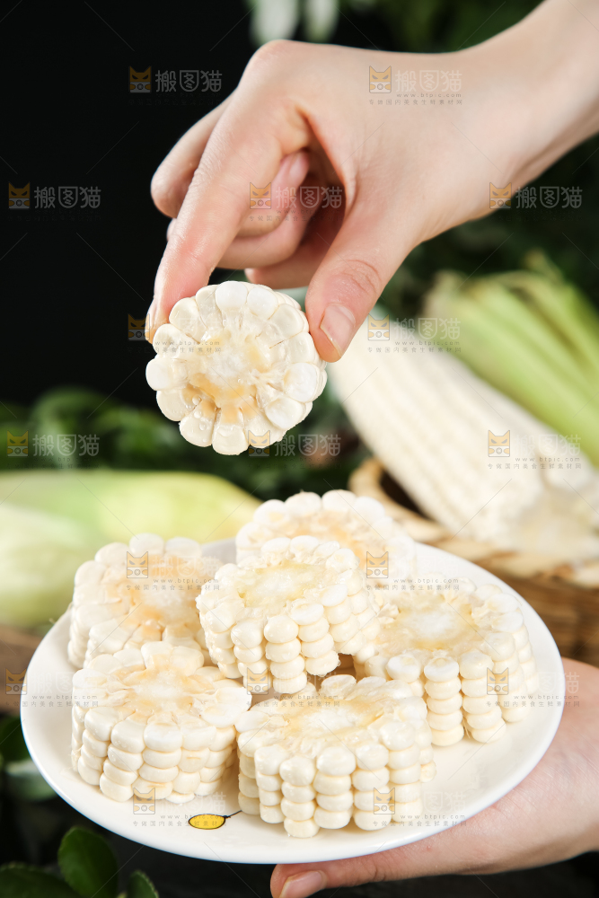 手里端着一盘玉米