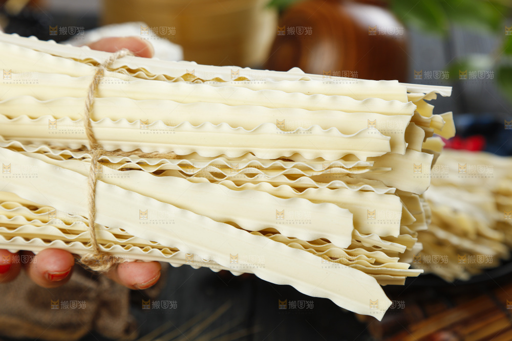 手上拿着手工刀削面