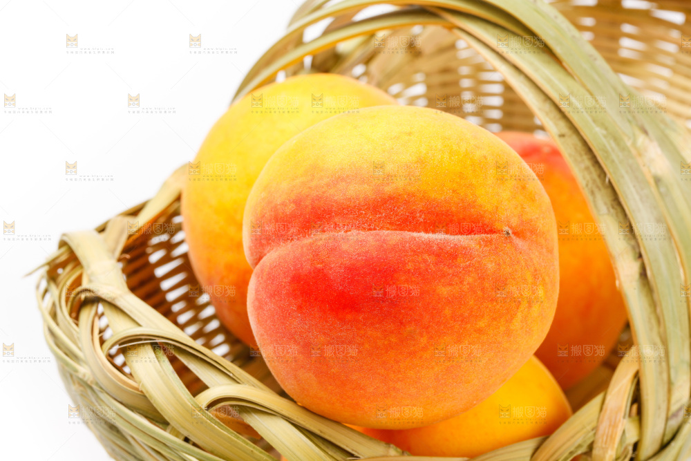 白底上放着一筐新鲜黄桃
