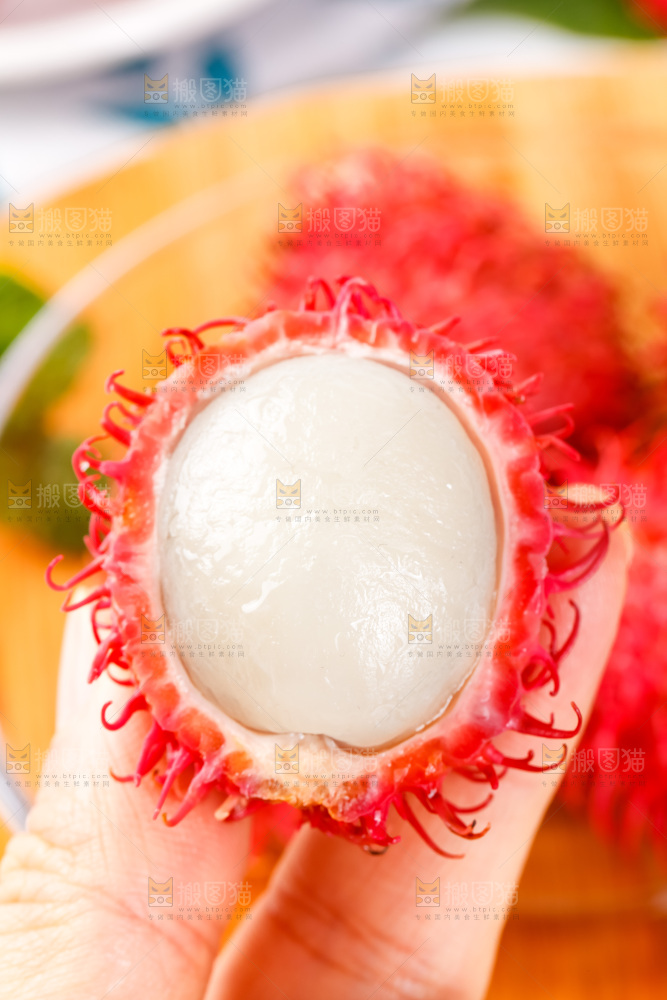 手里拿着新鲜红毛丹