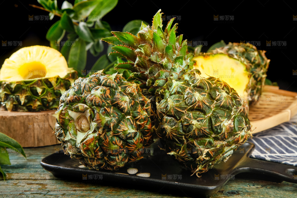 黑盘子上放着泰国小菠萝
