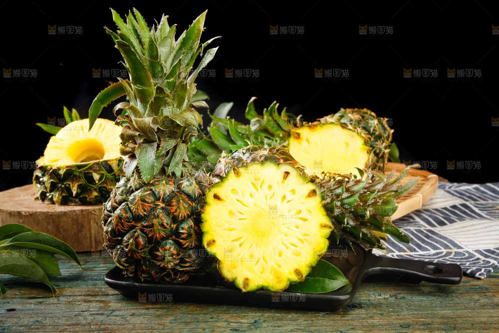 黑盘子上放着泰国小菠萝