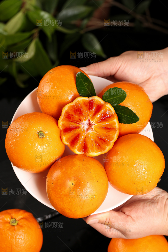 手里拿着一盘血橙