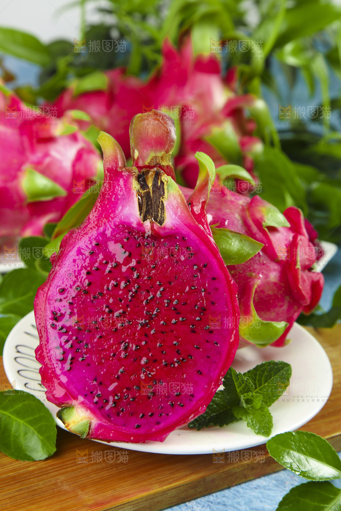 木板上放着切开的红肉火龙果