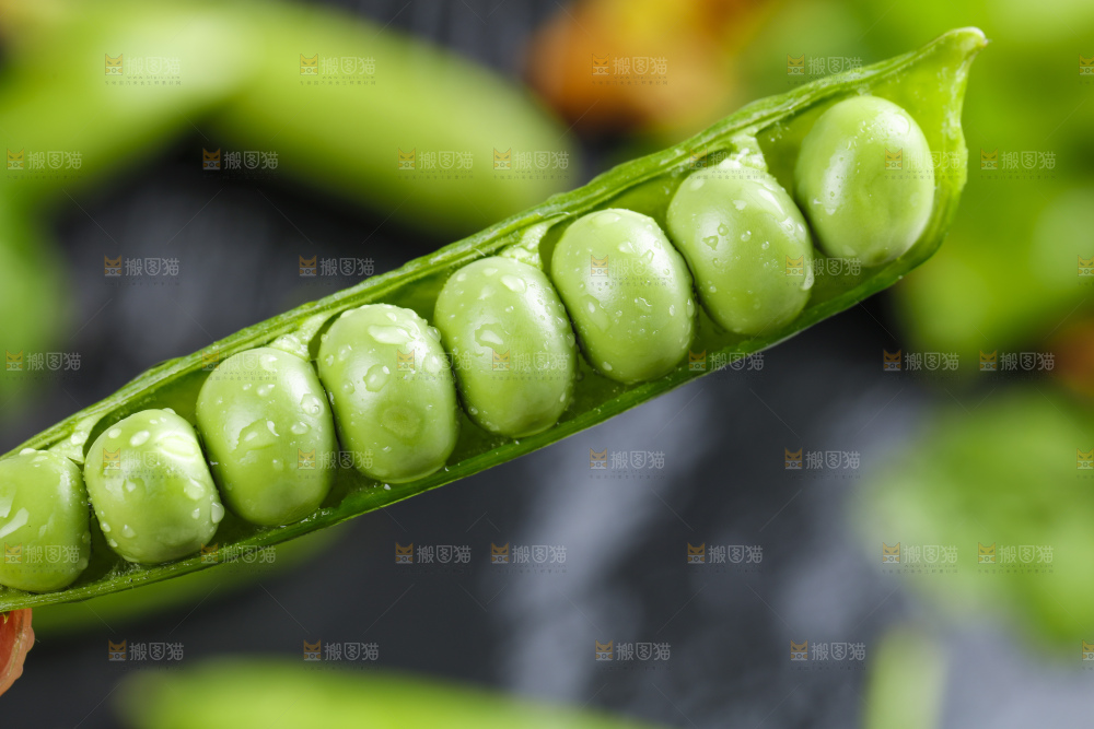 黑石板上堆放着甜豌豆