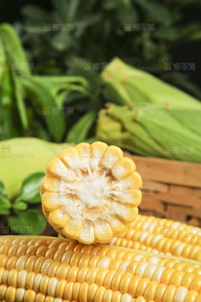 黑石板上放着掰开的玉米