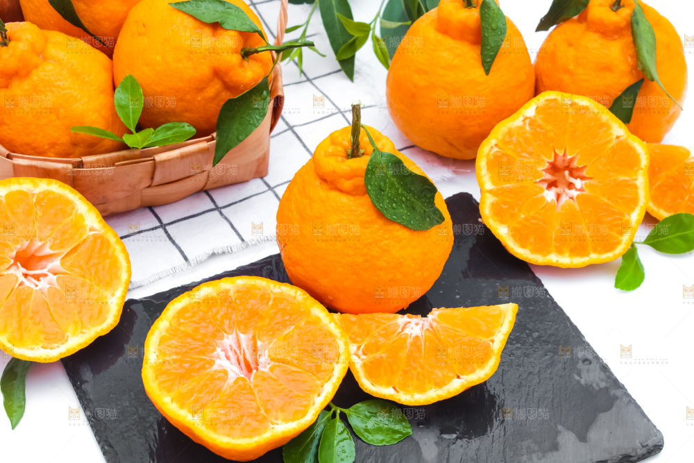 黑石板上放着切开的四川春见柑桔