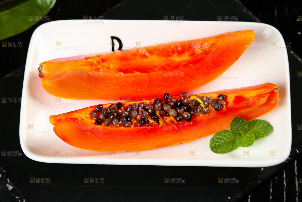 黑底上放着一盘切开的红心木瓜