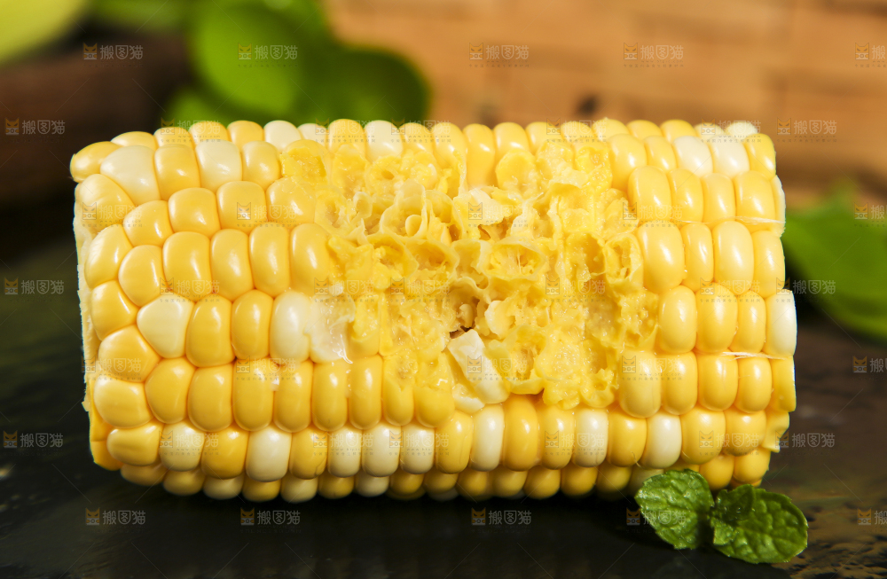 黑石板上放着咬过的甜玉米